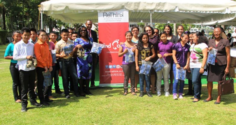 First Lady, Mrs. Sandra Granger; Ms. Valerie Garrido-Lowe, Junior Minister of Indigenous Peoples’ Affairs; Dr Karen Cummings, Junior Minister of Health; Mr. Dion Inniss, Caribbean Airlines representative and other officials pose with the students who proudly displayed their new shoes