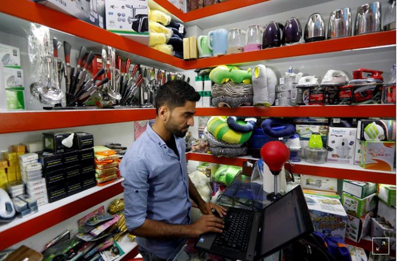 An Afghan shopkeeper works on his laptop at his online shop in Kabul, Afghanistan. (REUTERS)