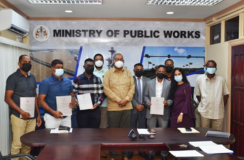 Minister of Public Works, Bishop Juan Edghill and Minister within the Ministry Deodat Indar with the contract awardees