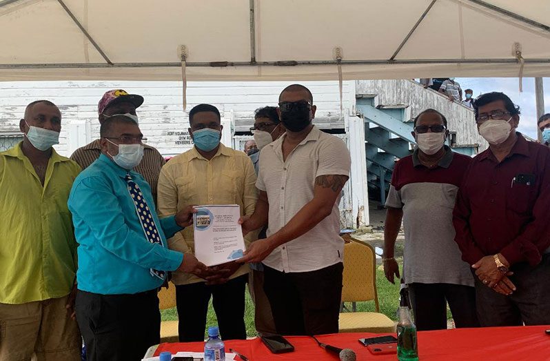Local Government and Regional Development Minister, Nigel Dharamlall, along with regional representatives witness the presentation of a contract to a representative of T and R Construction Services at the Port Mourant Community Centre Ground 