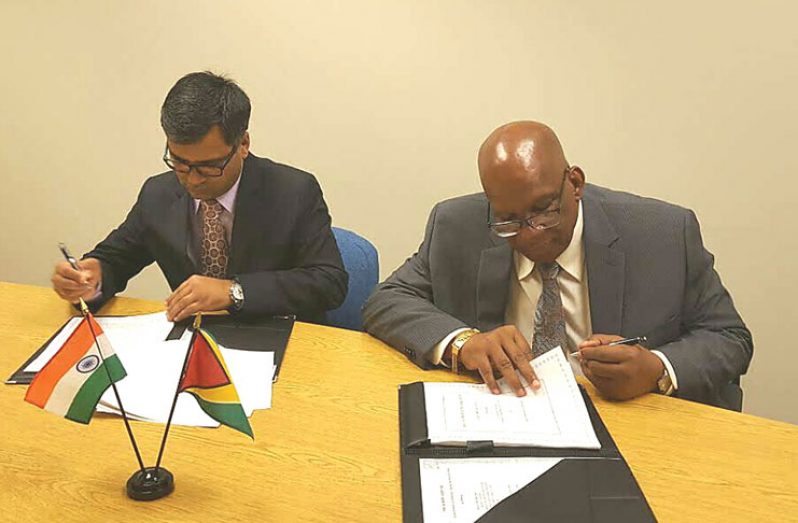 Minister of Finance, Winston Jordan (right) and Sailesh Prasad, Resident Representative on behalf of the Export-Import Bank of India, sign the agreement