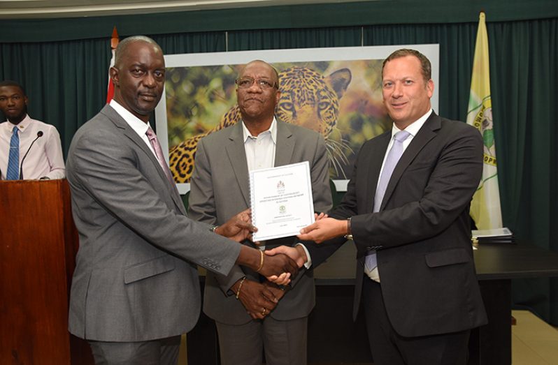 Commissioner of GLSC Trevor Benn and Managing-Director of Ordnance Survey International Peter Hedlund, hold the new agreement as Minister of State, Joseph Harmon watches on (Samuel Maughn photo)