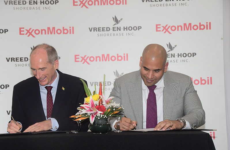 President of Exxon Mobil Guyana, Alistair Routledge (left) and Company Secretary of Vreed En Hoop Shorebase, Andron Alphonso sign the agreement (Adrian Narine photo)