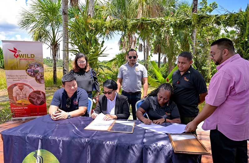 Stephen Su, President of the Chinese Association of Guyana; Minister of Tourism, Industry and Commerce, Hon. Susan Rodrigues and Shabana Daniels of Wild Adventures signing the Memorandum of Understanding (MoU) to develop and promote Hope Town, as a tourism product (Ministry of Tourism, Industry and Commerce photos)
