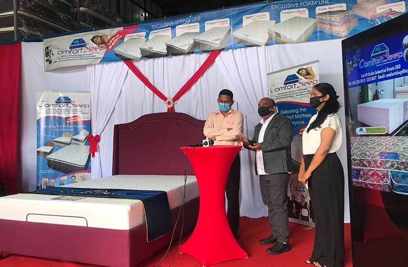 Comfort Sleep CEO, Mr. Dennis Charran (centre); his wife, Sabita (right); and local radio personality, Seegobin (left) during his address to attendees at the launch on Tuesday