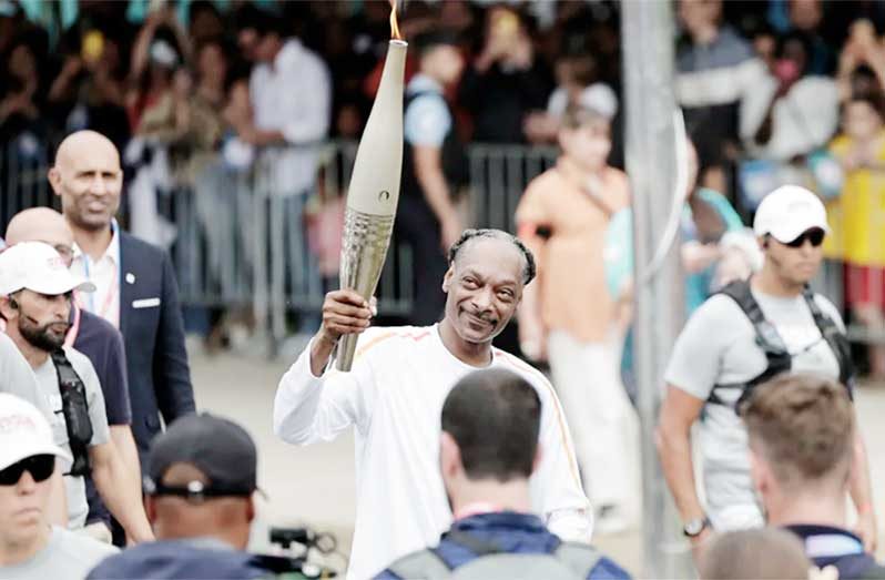 Snoop Dogg holds the torch as part of the 2024 Paris Olympic Games Torch Relay, on the day of the opening ceremony, in Saint-Denis, outside Paris, on July 26, 2024. Stephane de Sakutin/AFP/Getty Images