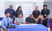 Dr. Renita Crandon Duncan, Principal of GTI (front row, second from left) and Earl Carribon, General Manager at Sol Guyana (front row, third from left) signing the agreement. Also pictured are Dr. Ritesh Tularam, Deputy Chief Education Officer (left) and staff members of Sol Guyana