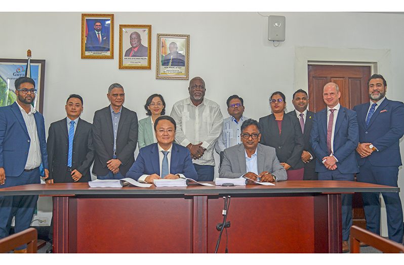 Prime Minister, Brigadier (Ret’d) Mark Phillips; Minister within the Ministry of Public Works, Deodat Indar; and Senior Minister in the Office of the President with responsibility for Finance and the Public Service, Dr Ashni Singh look on as officials signed the contracts (Japheth Savory photos)