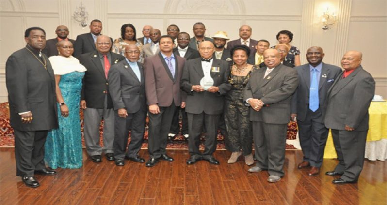 Colonel Cecil “Pluto” Martindale (centre), with gift, poses with members of the Guyana Ex-Soldiers of Canada