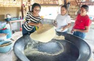 At Morai Rupununi Ranch in Katoonarib, Region Nine, a traditional experiential experience is being offered. Tourists can participate in bow and arrow making, cassava bread making and other activities. Photographed is Minister of Tourism, Industry and Commerce, Oneidge Walrond, learning the art of making cassava bread (Delano Williams photo)