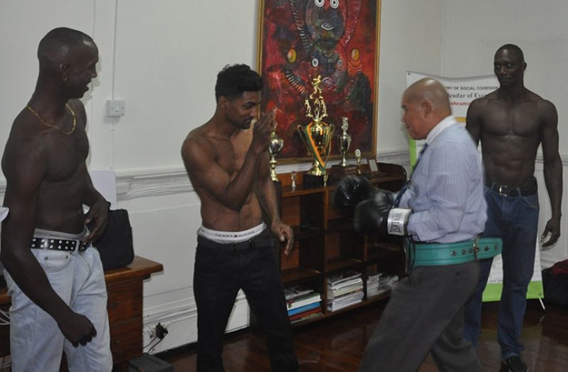 Minister of Sport Dr George Norton (2nd right) engages Guyana’s WBC CABOFE and International Continental bantamweight champion Elton `The Bully’ Dharry in a sparring session prior to yesterday’s press conference at the Minister’s Main Street office in the presence of Dexter `Cobra’ Gonsalves (extreme left) and Shawn Corbin (extreme right).