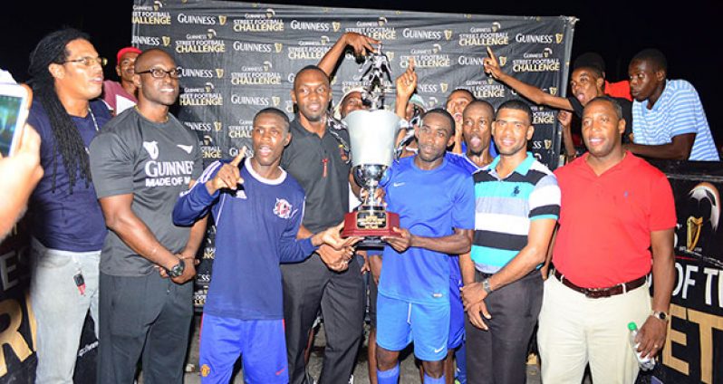 Director of Sport Director Chris Jones hands over the winners’ trophy to a jubilant  Sparta Boss team .
