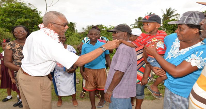 President David Granger shakes hands with one of the youngest residents of Kortberaadt, East Bank Berbice, during his recent visit there