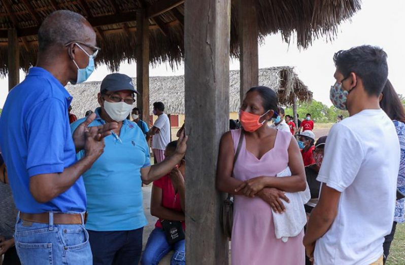 Labour Minister, Joseph Hamilton and Region Nine Chairman, Brian Allicock, interact with residents during the distribution exercise (DPI photo)