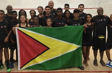 Winners! The winning Guyana Junior Squash team lifting the Golden Arrowhead, with team coach Carl Ince (second from right), and other officials