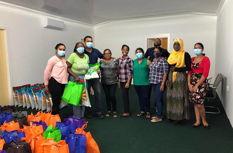 Regional Executive Officer, Devanand Ramdatt, with some of the staffers who received hampers