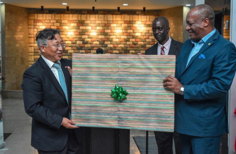 Minister of State Mr. Joseph Harmon, presents a token of appreciation to Chinese Ambassador to Guyana, Mr. Cui Jianchun in recognition of China's contribution to the hosting of CRIC 17