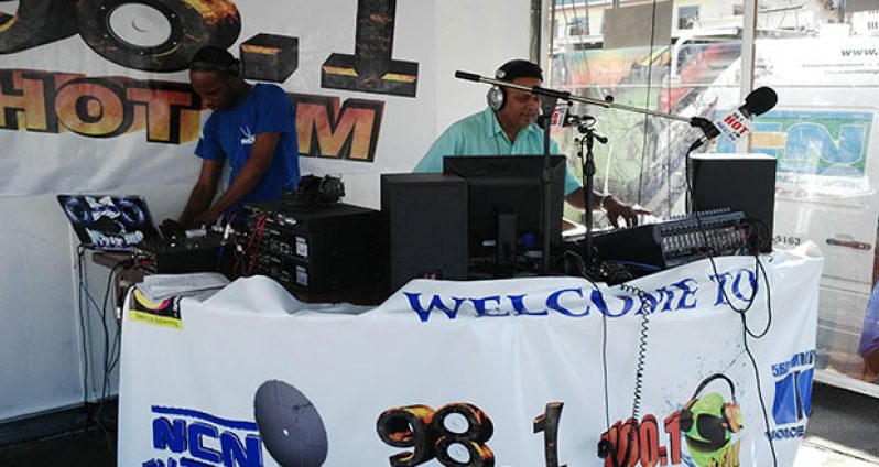 Radio Announcer Seegobin and Quacy Coates, called “Avalanche”, in action on Friday last during the live road show at Stabroek Square.