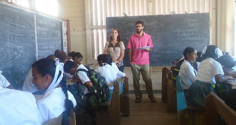 Students of the Lower Corentyne Secondary listen as Peace Corps volunteers Kayla Freemon and Zack Keefer speak about self-esteem.
