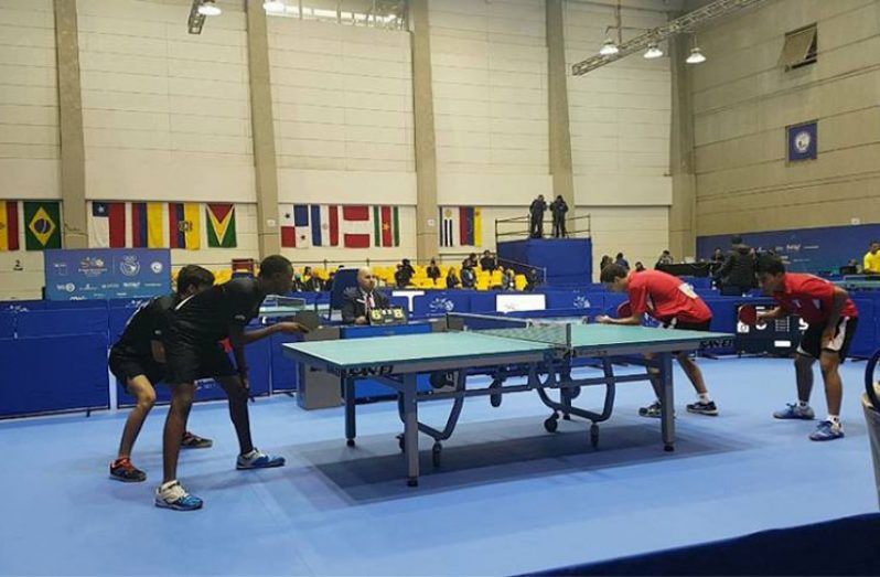 Guyana’s Boys Miguel Wong (left) and Nickolus Romain in action during the table tennis Boys’ team competition