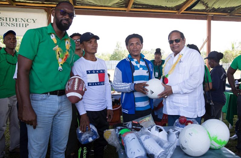 Prime Minister, Hon. Moses Nagamootoo and Director of Sport, Christopher Jones donate a quantity of sport gear to the Port Kaituma community