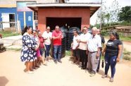 Minister of Housing and Water, Collin Croal, hands over black tanks to Citrus Grove