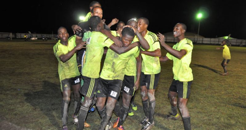 Hat-trick Boy! Grove Hi Tech leading marksman Domini Garnett (#11)  mobbed by teammates after he scores the winning goal against NA United at the Buxton ground.