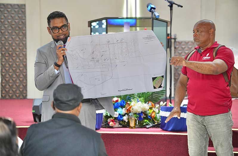 President Ali on Sunday announced that the land titling process for Timehri North has commenced and over 600 households are set to benefit. In this DPI photo, President Ali holds up a map of the area while addressing residents