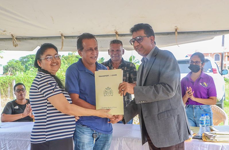 Attorney General and Minister of Legal Affairs, Anil Nandlall, S.C. hands over the land- ownership document to a Plantation Hope couple (Department of Public Information photo)