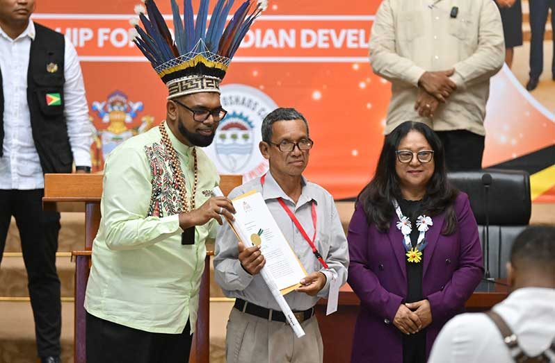 Toshao of Hotoquai, Carson Thomas (centre) receives the absolute grant from President, Dr. Irfaan Ali (left) and Minister of Amerindian Affairs, Pauline Sukhai (right) (Samuel Maughn photo)