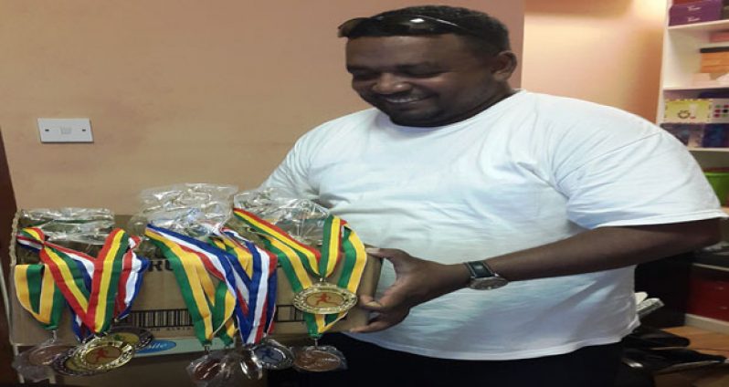 Rajan Tiwari of Payless Variety Store displays the trophies and medals that will be up for grabs tomorrow.