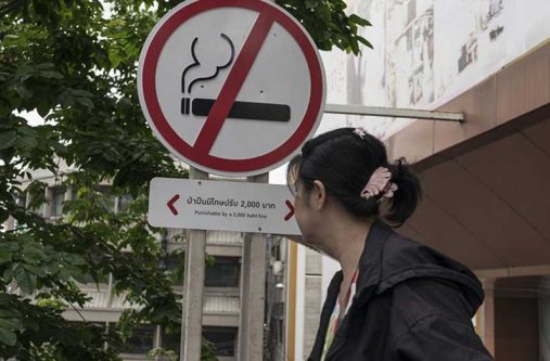 A woman walks past a no smoking sign outside a shopping centre in Bangkok, Thailand (WHO/Conor Ashleigh photo)