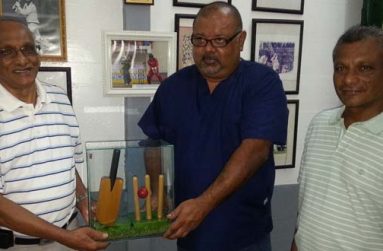 Deopaul Raghubir (left) the grandfather of Omesh Mohammed, presents the turf from the ‘square’ at Lord’s, along with a wicket, ball and bat ornament to GCC president Lionel Jaikarran, while Prem Raghubir looks on appreciatively at right.