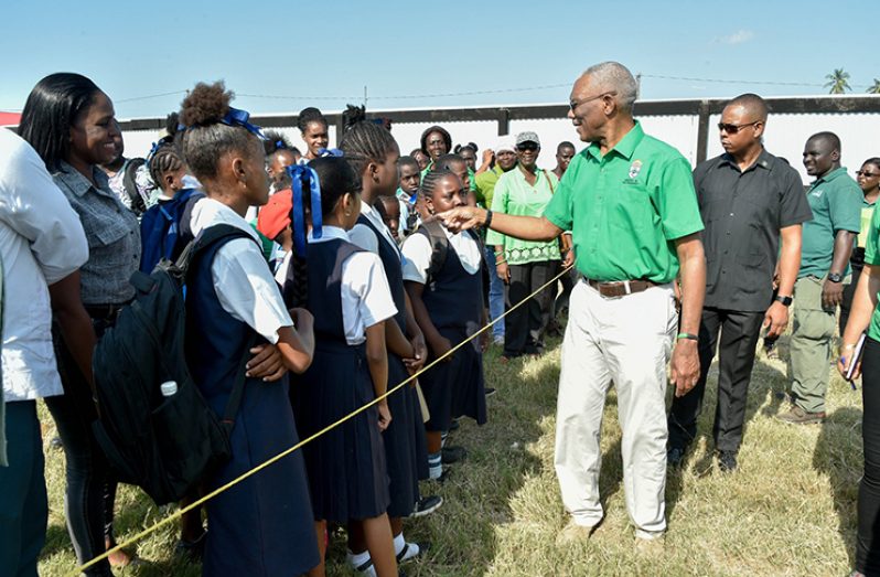 President David Granger interacts with students on the Corentyne during the National Tree Planting Day on Friday