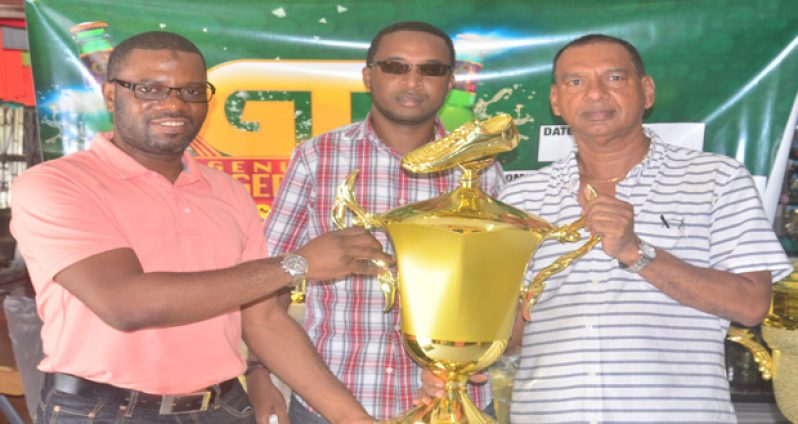 UDFA president Sharma Solomon receives the first-place trophy from Ramesh Sunich of Trophy Stall while Jeoff Clement GT Beer Brand manager looks on.