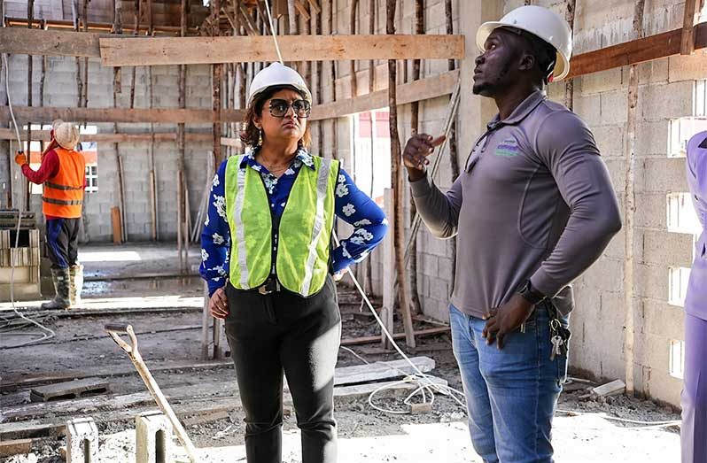 Minister of Education, Priya Manickchand, speaks with a contractor during the site visit on Wednesday