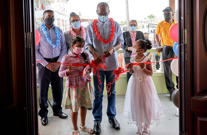 Labour Minister Joseph Hamilton cutting the ceremonial ribbon to officially declare open the Anna Regina labour office on Friday