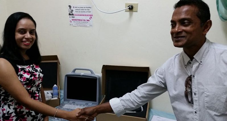 Dr. Alesha Bulkan, ultrasound specialist at the Mahaicony Hospital, receiving the modern ultrasound equipment from Chief Operations Officer of the GMR, Sharir Chan