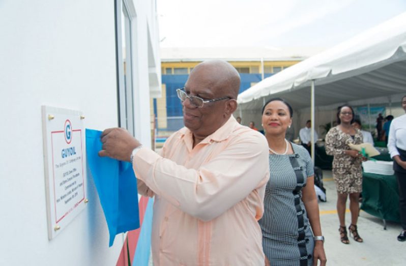 Minister of Finance, Hon. Winston Jordan unveils the plaque to commission the GUYOIL ‘green’ store and complex