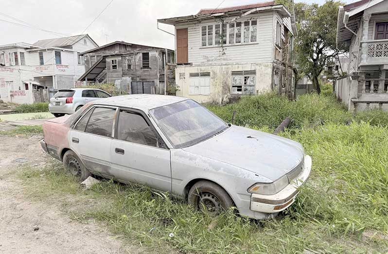 A derelict vehicle on the road shoulder of a city street (Ministry of Public Works photo)