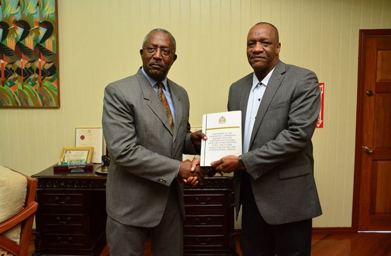 Minister of State, Mr. Joseph Harmon, receiving the report from Colonel Desmond Roberts at the Ministry of the Presidency