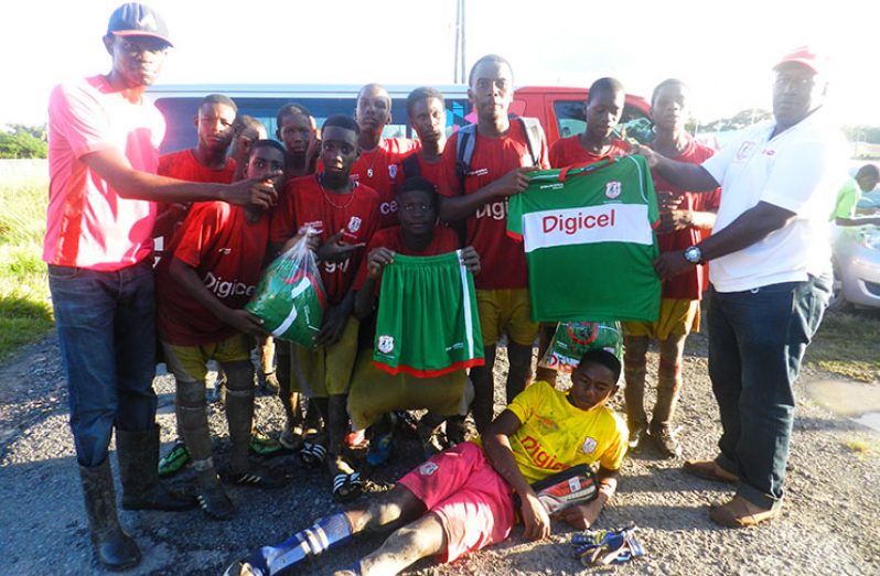 A victorious Vryman’s Erven Secondary team with teacher (far left in pink shirt), while a Digicel representative makes a kit presentation to the winners.