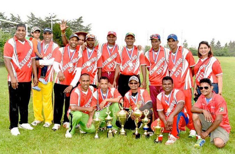 The victorious Essequibo team pose with  supporters.