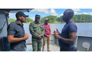 Region Two Chairman, Devin Mohan; Deputy Regional Executive Officer, Omesh Sasenarayan and Captain Anthony Lyttle interact with a rank during a visit to the Coast Guard floating vessel in Lower Pomeroon River