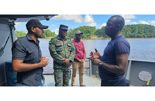 Region Two Chairman, Devin Mohan; Deputy Regional Executive Officer, Omesh Sasenarayan and Captain Anthony Lyttle interact with a rank during a visit to the Coast Guard floating vessel in Lower Pomeroon River