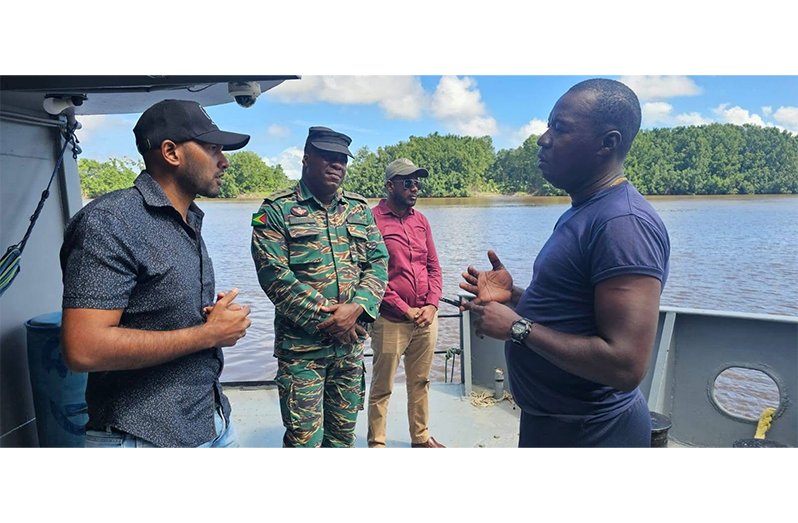 Region Two Chairman, Devin Mohan; Deputy Regional Executive Officer, Omesh Sasenarayan and Captain Anthony Lyttle interact with a rank during a visit to the Coast Guard floating vessel in Lower Pomeroon River