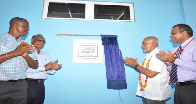 President Donald Ramotar, second from right, unveils a plaque declaring the warm-up pool open. Looking on are (from left) MCYS Permanent Secretary, Alfred King, Director of Sport Neil Kumar and Minister of Culture, Youth and Sport Dr Frank Anthony (Photo by Delano Williams)