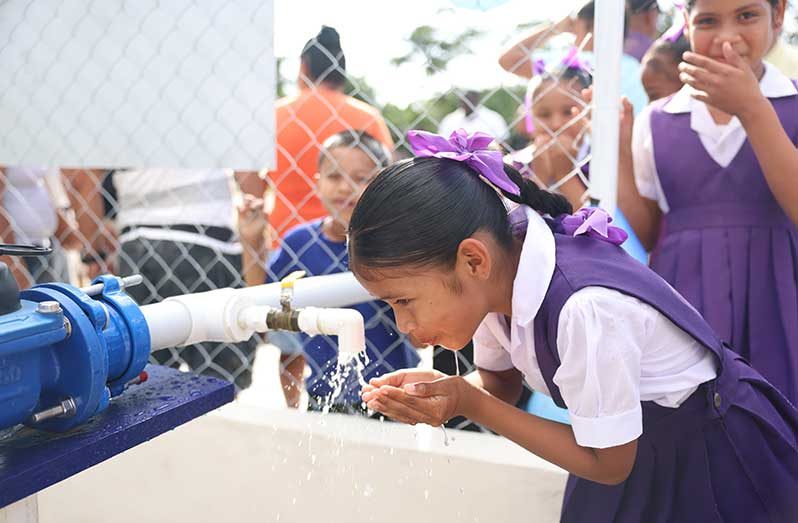 A young child of Falmouth was the first to sample the water from the new multimillion-dollar water supply system (Ministry of Housing and Water photo)