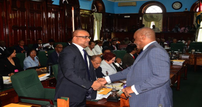 Welcome! Opposition Leader Bharrat Jagdeo is greeted by Minister of State Joseph Harmon on his arrival in the Parliament chamber