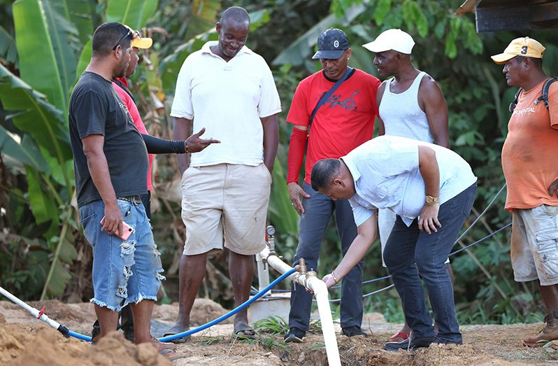 Minister of Housing and Water Collin Croal and other officials at Oronoque where a well is being dug